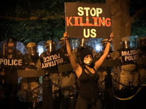 Protester holding sign Stop Killing Us