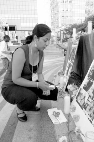 Xiomera Castro lights a candle at a Silence the Violence vigil in Oakland, CA