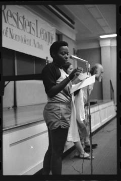 Mandy Carter speaking at the July 1983 WRL conference. Behind her are Linnea Capps and Igal Roodenko.